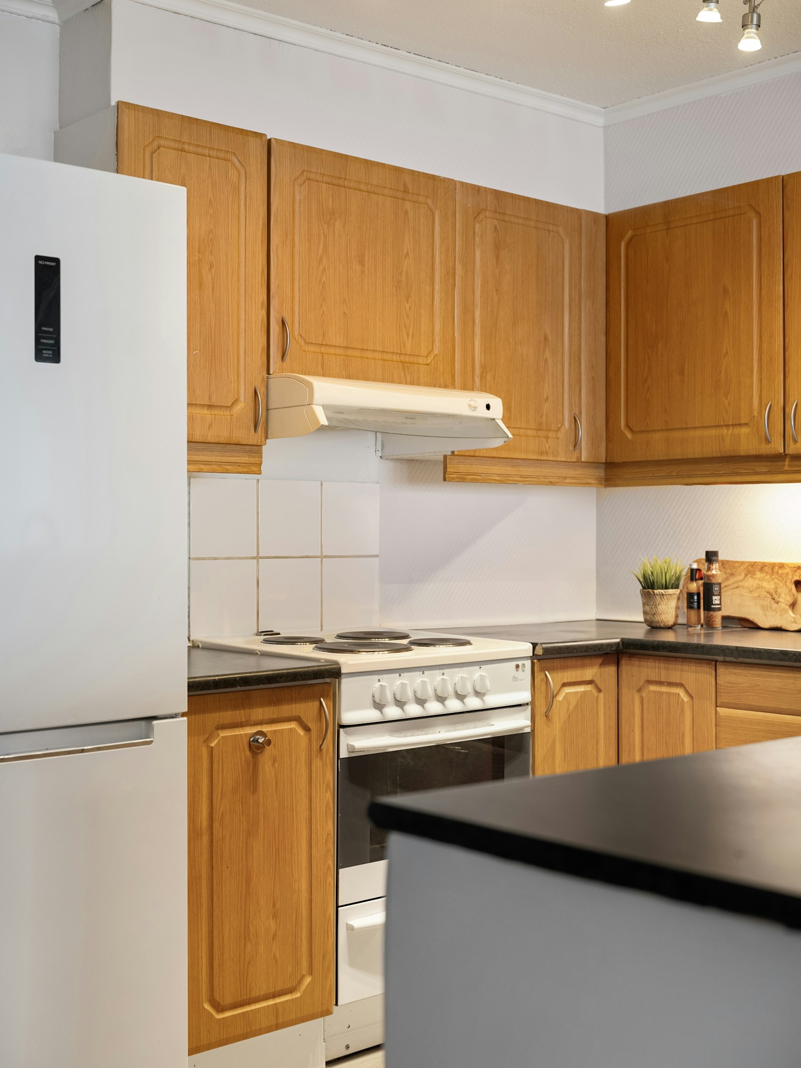 Nevera blanca en una cocina doméstica con horno y encimera