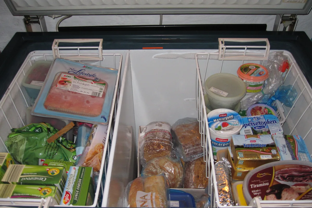 Arcón congelador abierto con alimentos organizados